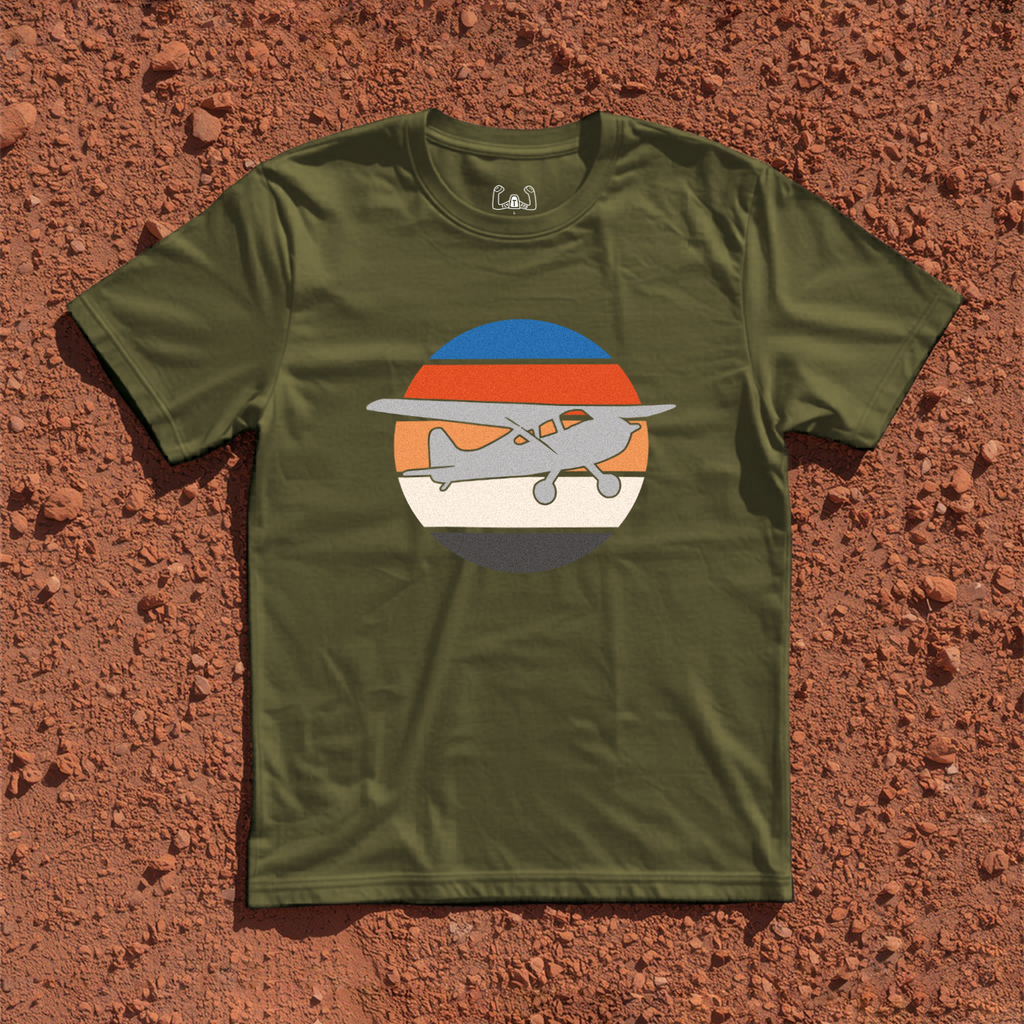 Silhouette Of A Bush Plane Flying Up to The Right Through Retro Sunset Tee