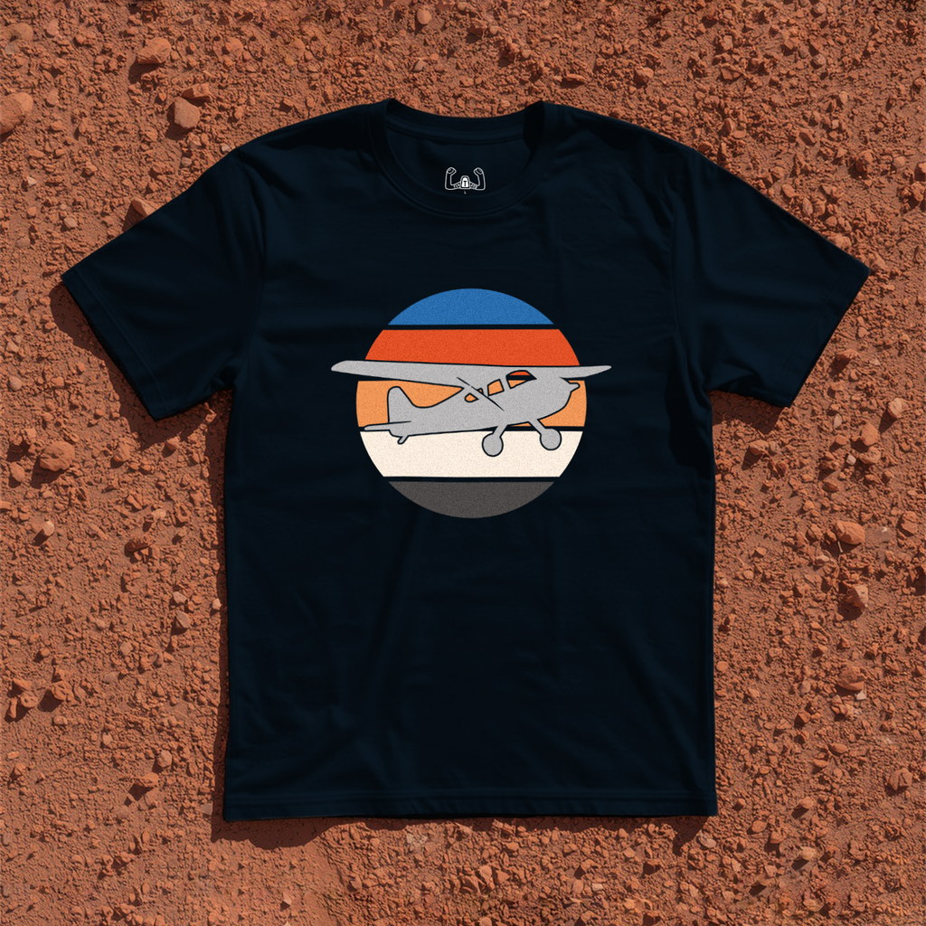 Silhouette Of A Bush Plane Flying Up to The Right Through Retro Sunset Tee